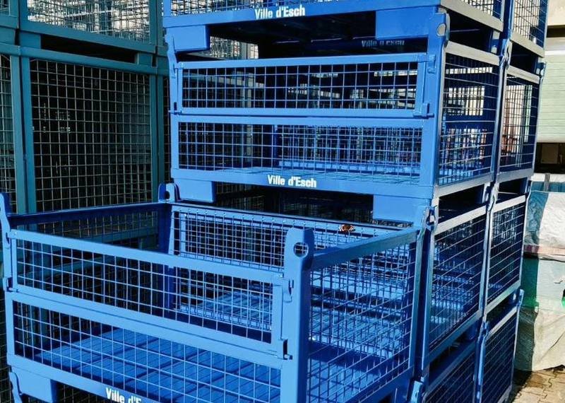 Blue powder-coated steel mesh containers stacked four high with customer marking