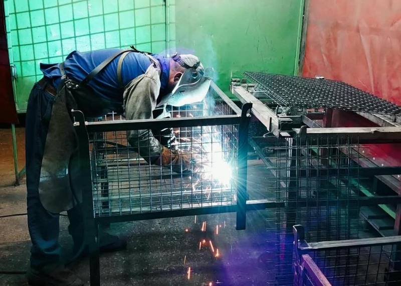 Welder assembling a steel container frame